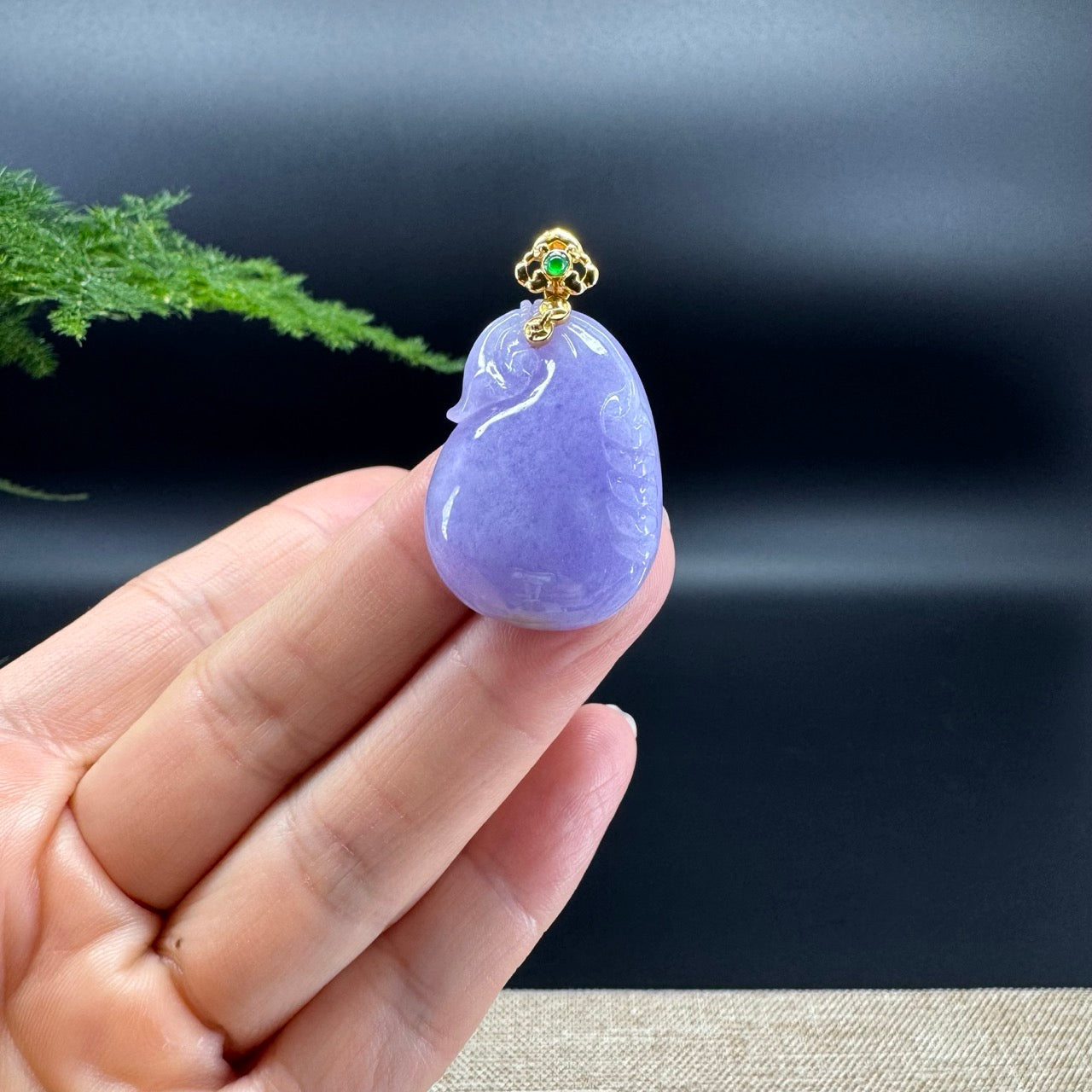 The shape of the pendant is that of a pdd lucky bag. The jade is lavender color, and it is surrounded by 18k yellow gold with diamonds.