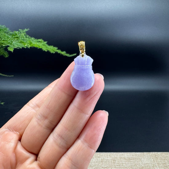 The shape of the pendant is that of a money sack. The jade is lavender color, and it is surrounded by 18k yellow gold.