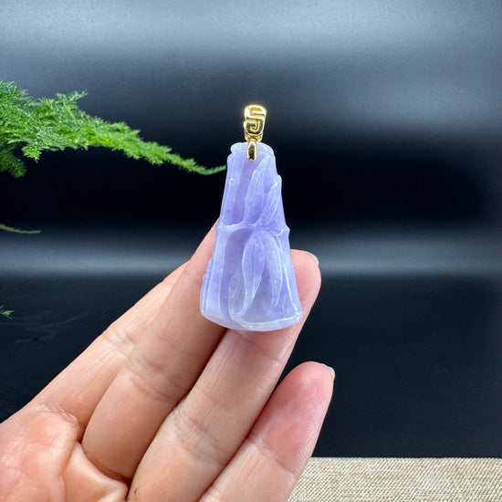 The shape of the pendant is that of a bamboo. The jade is lavender color, and it is surrounded by 18k yellow gold.