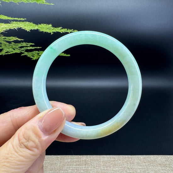 The bangle shape is a round.The jade is that of apple green and yellow colors.