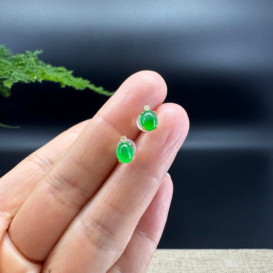 The shape of the ring is that of a round. The jade is imperial green color, and it is surrounded by 18k yellow gold with diamonds.