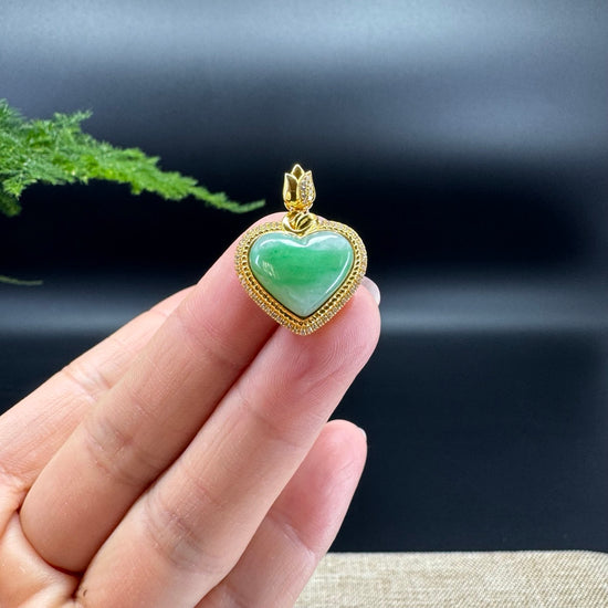 The shape of the pendant is heart， and the jade is a  spicy green color. It is surrounded by 18k gold with diamonds.