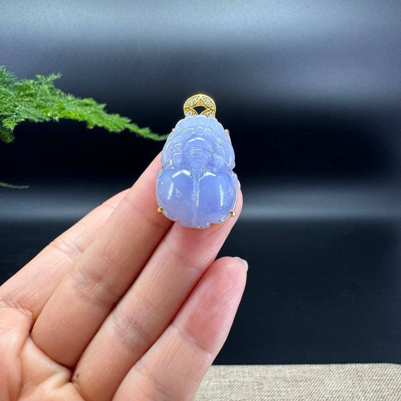 The shape of the pendant is that of a pixiu. The jade is lavender color, and it is surrounded by 18k yellow gold.
