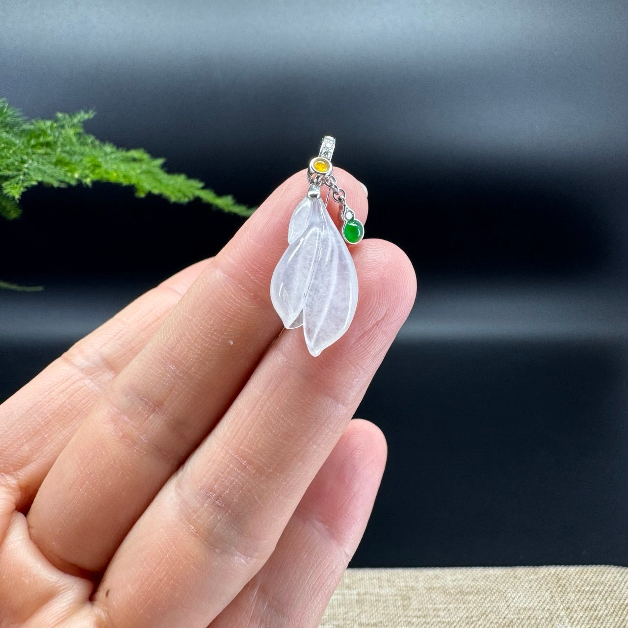 The shape of the pendant is that of a magnolia flower. The jade is icy color, with 18k white gold and diamonds bail.