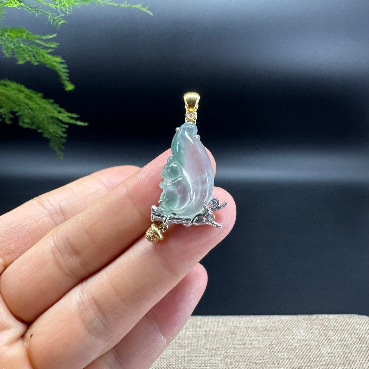 The pendant shape of the squirrel.The jade color is icy blue green.